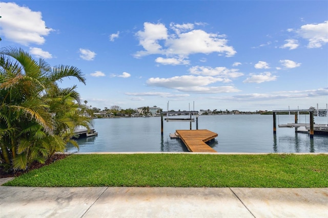 dock area featuring a water view, a lawn, and boat lift