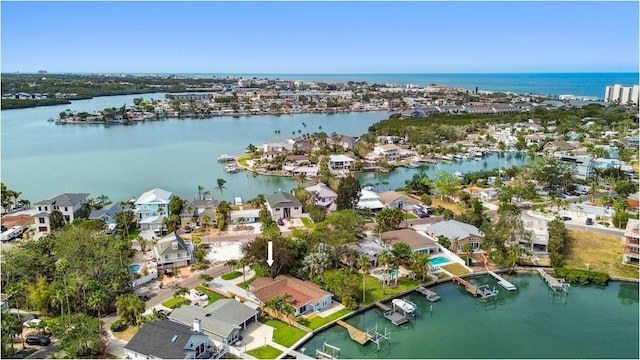 aerial view of property and surrounding area featuring a nearby body of water and nearby suburban area