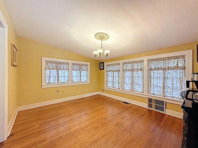 800 W Lake Elbert Dr NE, Winter Haven, FL 33881 - unfurnished dining area with a chandelier, hardwood / wood-style flooring, and vaulted ceiling