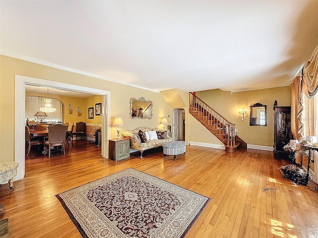 800 W Lake Elbert Dr NE, Winter Haven, FL 33881 - living area featuring arched walkways, stairway, light wood-style flooring, healthy amount of natural light, and ornamental molding