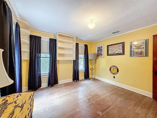 800 W Lake Elbert Dr NE, Winter Haven, FL 33881 - unfurnished bedroom with multiple windows, crown molding, and wood finished floors