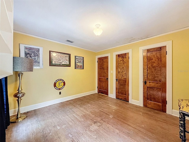 800 W Lake Elbert Dr NE, Winter Haven, FL 33881 - unfurnished bedroom featuring ornamental molding, wood finished floors, and two closets