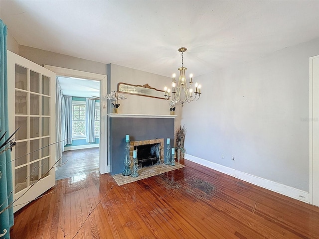 800 W Lake Elbert Dr NE, Winter Haven, FL 33881 - unfurnished living room featuring a chandelier, wood-type flooring, and a fireplace with flush hearth