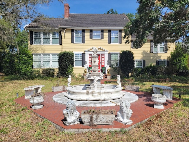 800 W Lake Elbert Dr NE, Winter Haven, FL 33881 - view of front facade with a chimney and a front lawn
