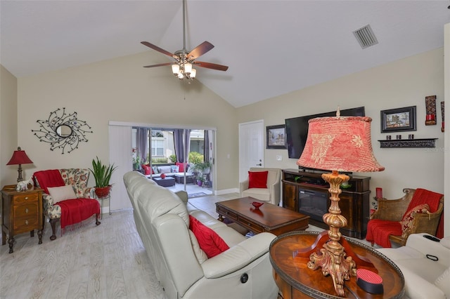 living area featuring high vaulted ceiling, a ceiling fan, and wood finished floors