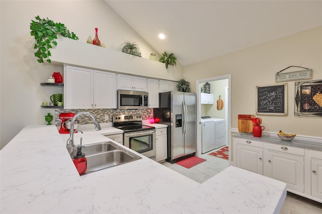 815 Silverthorn Ln Unit 0, Sun City Center, FL 33573 - kitchen with stainless steel appliances, washer and clothes dryer, open shelves, a sink, and decorative backsplash