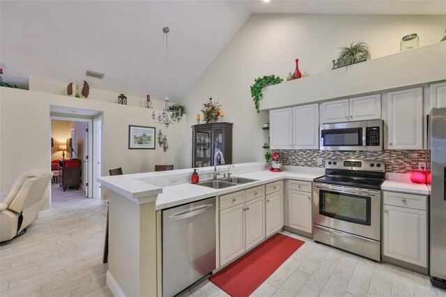 815 Silverthorn Ln Unit 0, Sun City Center, FL 33573 - kitchen featuring appliances with stainless steel finishes, a sink, light countertops, a peninsula, and high vaulted ceiling