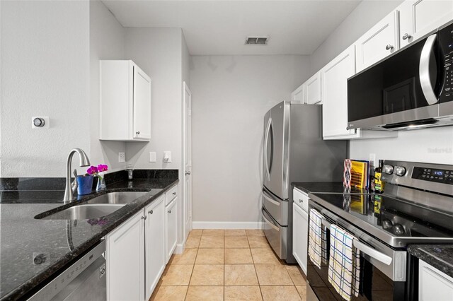 5000 Culbreath Key Way Unit 8-319, Tampa, FL 33611 - kitchen with stainless steel appliances, a sink, white cabinets, dark stone counters, and baseboards