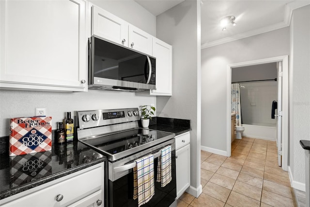 5000 Culbreath Key Way Unit 8-319, Tampa, FL 33611 - kitchen with stainless steel appliances, ornamental molding, white cabinets, dark stone counters, and baseboards