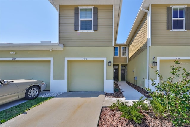 view of front of house featuring concrete driveway, stucco siding, and a garage