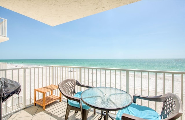 balcony featuring a water view, grilling area, and a view of the beach