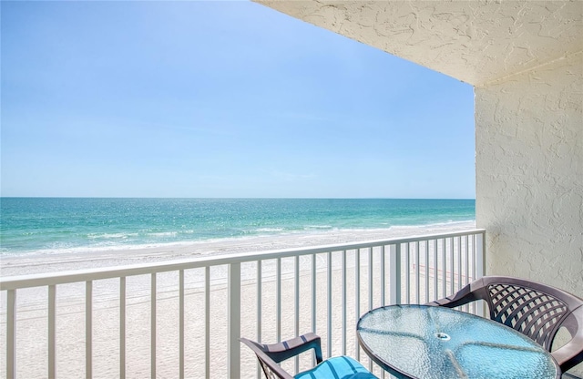 balcony featuring a water view and a view of the beach