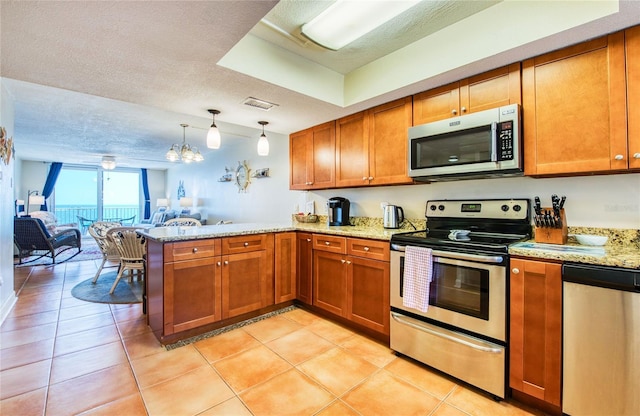kitchen with a peninsula, brown cabinets, visible vents, open floor plan, and appliances with stainless steel finishes