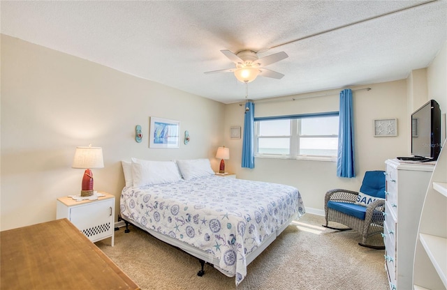carpeted bedroom featuring a textured ceiling, baseboards, and a ceiling fan