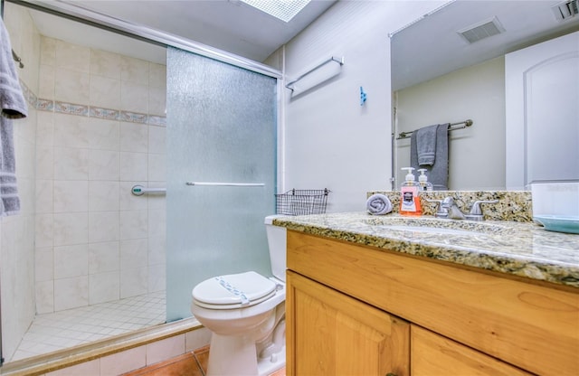 bathroom featuring vanity, toilet, visible vents, and a shower stall