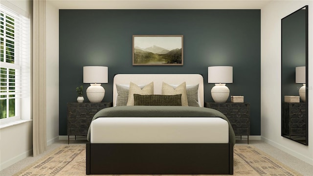 bedroom with an accent wall, light carpet, and baseboards