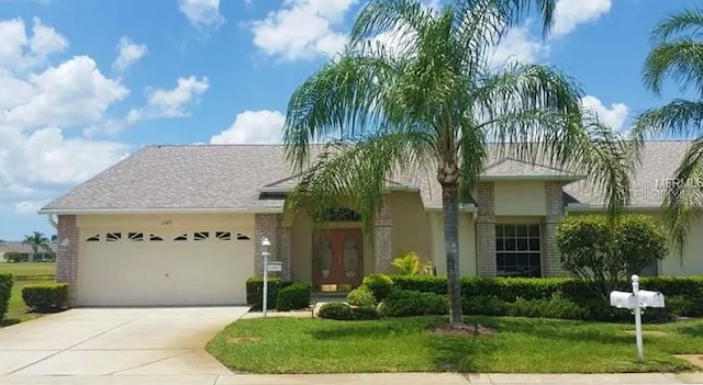 ranch-style home featuring french doors, brick siding, a garage, concrete driveway, and a front yard