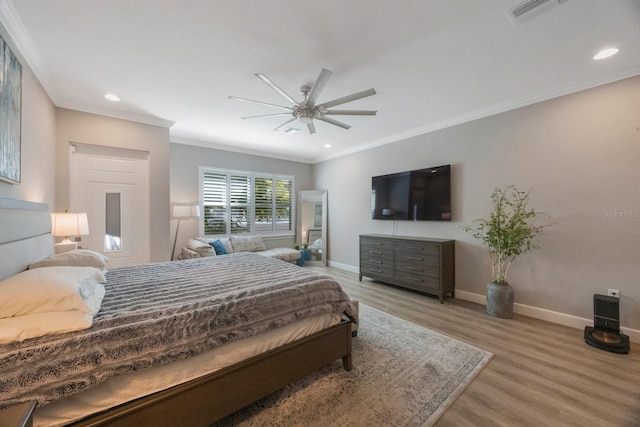 bedroom featuring light wood finished floors, crown molding, baseboards, and recessed lighting