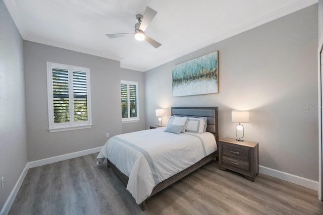 bedroom with crown molding, light wood-style flooring, and baseboards