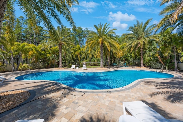 community pool featuring fence and a patio
