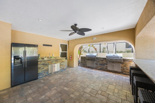 view of patio featuring a sink, grilling area, exterior kitchen, and a ceiling fan