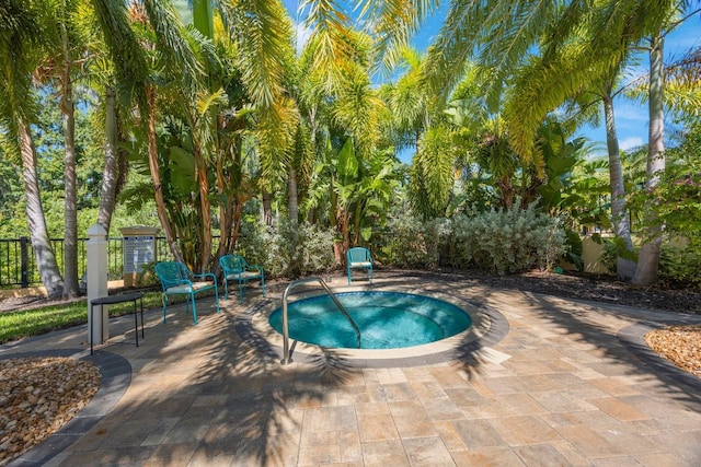 view of pool featuring a patio area, a community hot tub, and fence