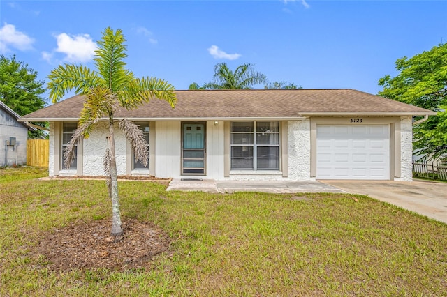 ranch-style home featuring a front lawn, driveway, a garage, and fence