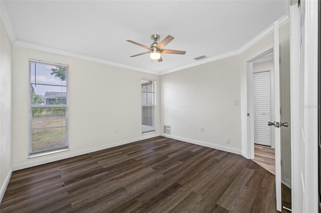 interior space with crown molding, baseboards, visible vents, and dark wood finished floors