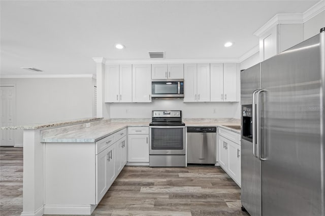 kitchen with recessed lighting, ornamental molding, visible vents, a peninsula, and appliances with stainless steel finishes