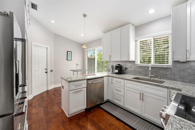 3268 Tanglewood Trl, Palm Harbor, FL 34685 - kitchen with stainless steel appliances, a sink, a peninsula, decorative backsplash, and vaulted ceiling