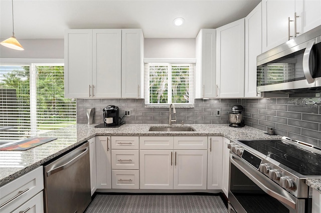 3268 Tanglewood Trl, Palm Harbor, FL 34685 - kitchen featuring appliances with stainless steel finishes, a sink, white cabinets, backsplash, and healthy amount of natural light