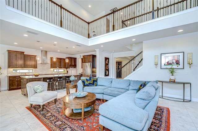 living room with a high ceiling, recessed lighting, light tile patterned floors, stairs, and baseboards