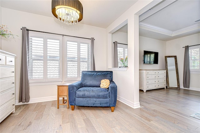 sitting room with light wood-style floors, a chandelier, baseboards, and ornamental molding