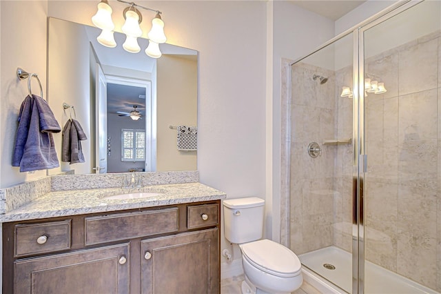 full bathroom with a shower stall, toilet, vanity, and ceiling fan