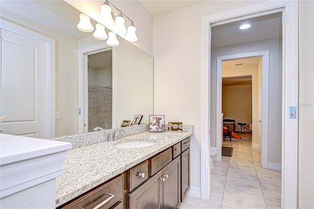bathroom featuring toilet, tile patterned flooring, vanity, and baseboards
