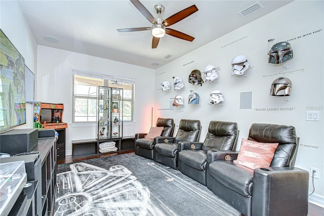 home theater with ceiling fan, dark wood-type flooring, and baseboards