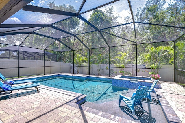 view of swimming pool with an in-ground hot tub, a patio area, a fenced backyard, and glass enclosure
