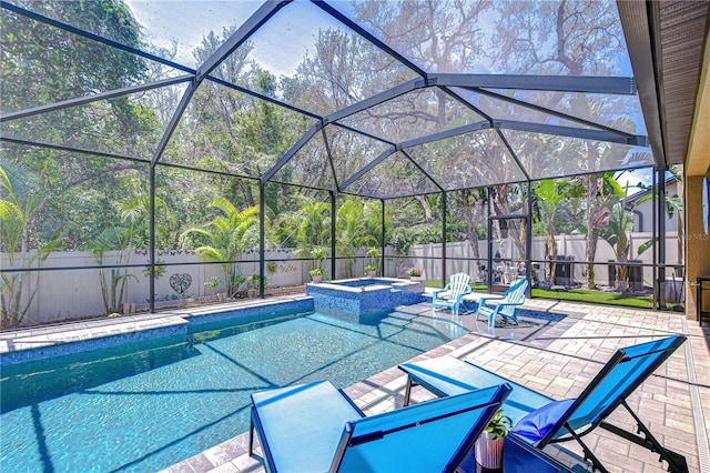 view of swimming pool featuring a patio area, a fenced backyard, a pool with connected hot tub, and a lanai