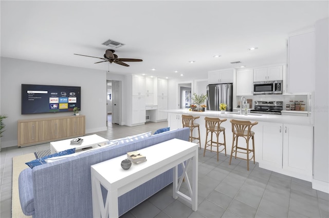 living room featuring a ceiling fan, recessed lighting, and light tile patterned flooring