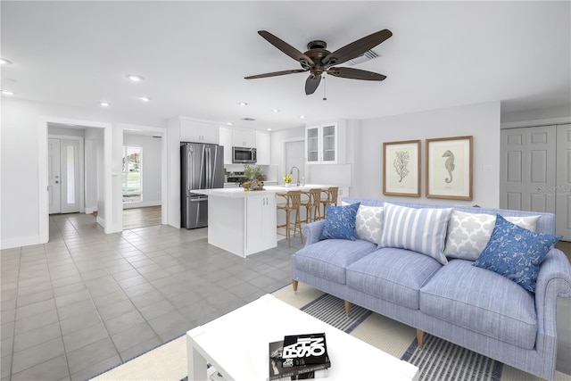 living room featuring ceiling fan, recessed lighting, and baseboards