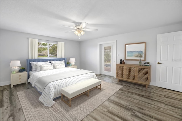 bedroom with wood finished floors, a ceiling fan, baseboards, and access to outside