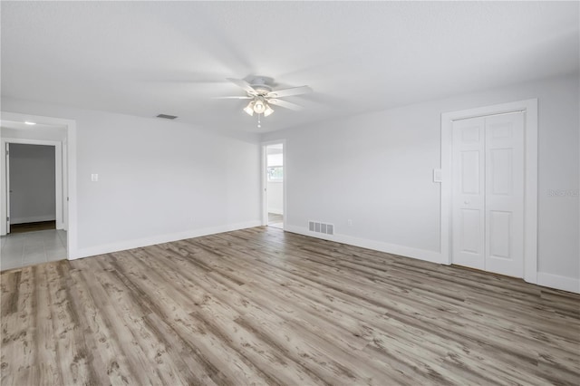unfurnished room with a ceiling fan, baseboards, and wood finished floors