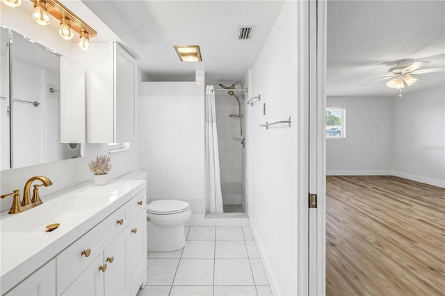 bathroom featuring toilet, baseboards, a ceiling fan, and a tile shower