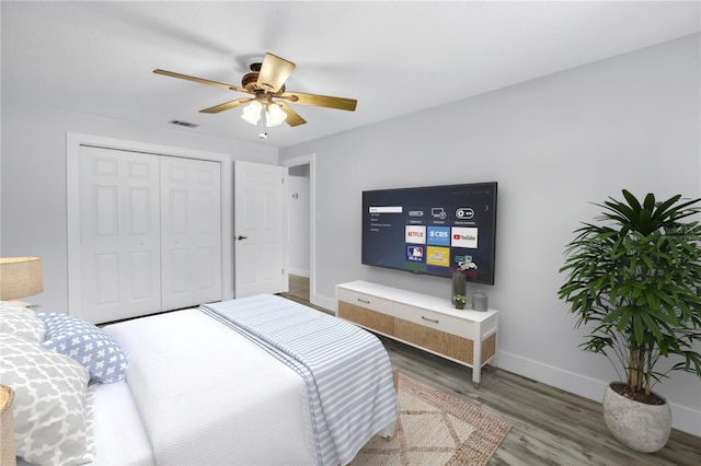 bedroom featuring wood finished floors, baseboards, a closet, and ceiling fan