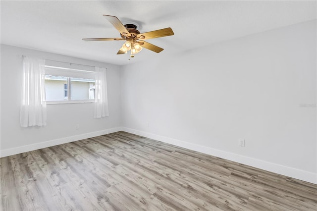 unfurnished room with baseboards, wood finished floors, and a ceiling fan