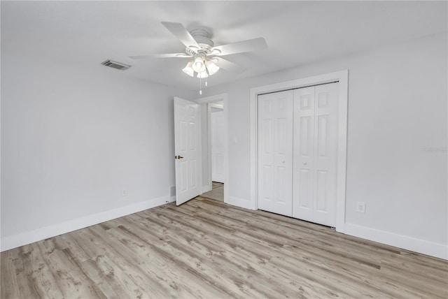 unfurnished bedroom featuring wood finished floors, baseboards, a closet, and a ceiling fan