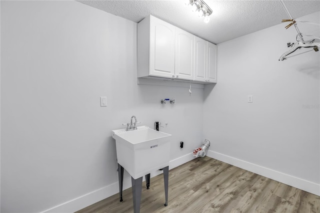 laundry room featuring cabinet space, baseboards, hookup for a washing machine, hookup for a gas dryer, and a textured ceiling