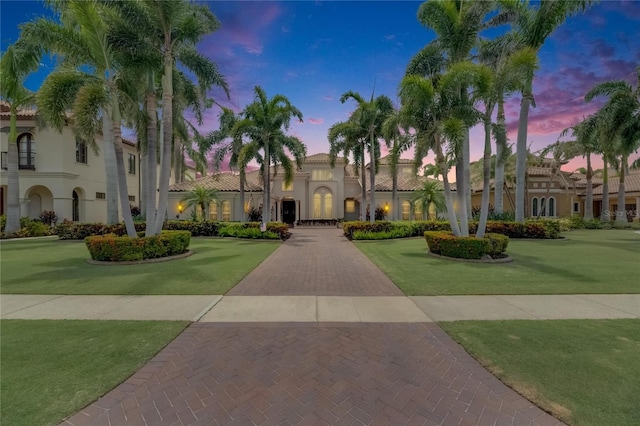 mediterranean / spanish-style home with stucco siding and a front lawn