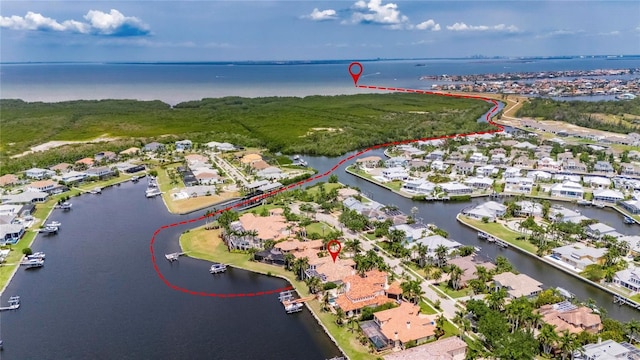 aerial view of property and surrounding area featuring a nearby body of water and nearby suburban area