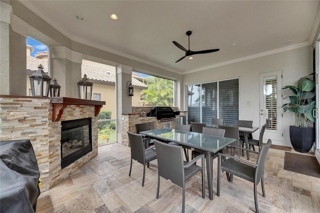 view of patio featuring an outdoor stone fireplace, outdoor dining area, an outdoor kitchen, area for grilling, and ceiling fan